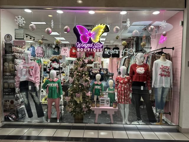Inside Winged Star Boutique storefront with curated fashion displays at Greentree Mall